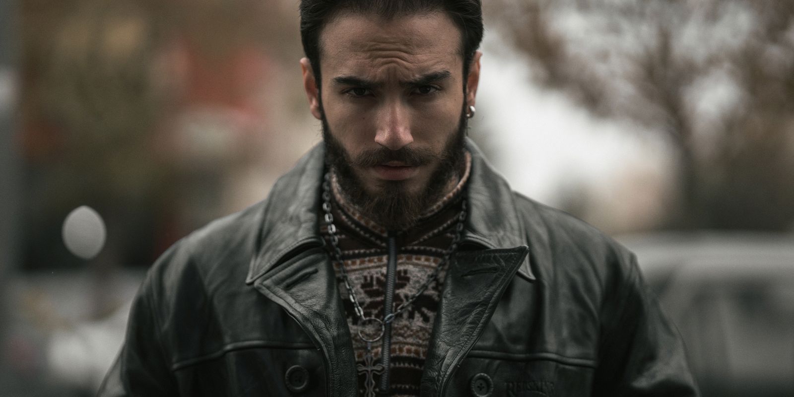 A fashionable man wearing a classic leather jacket, editorial portrait