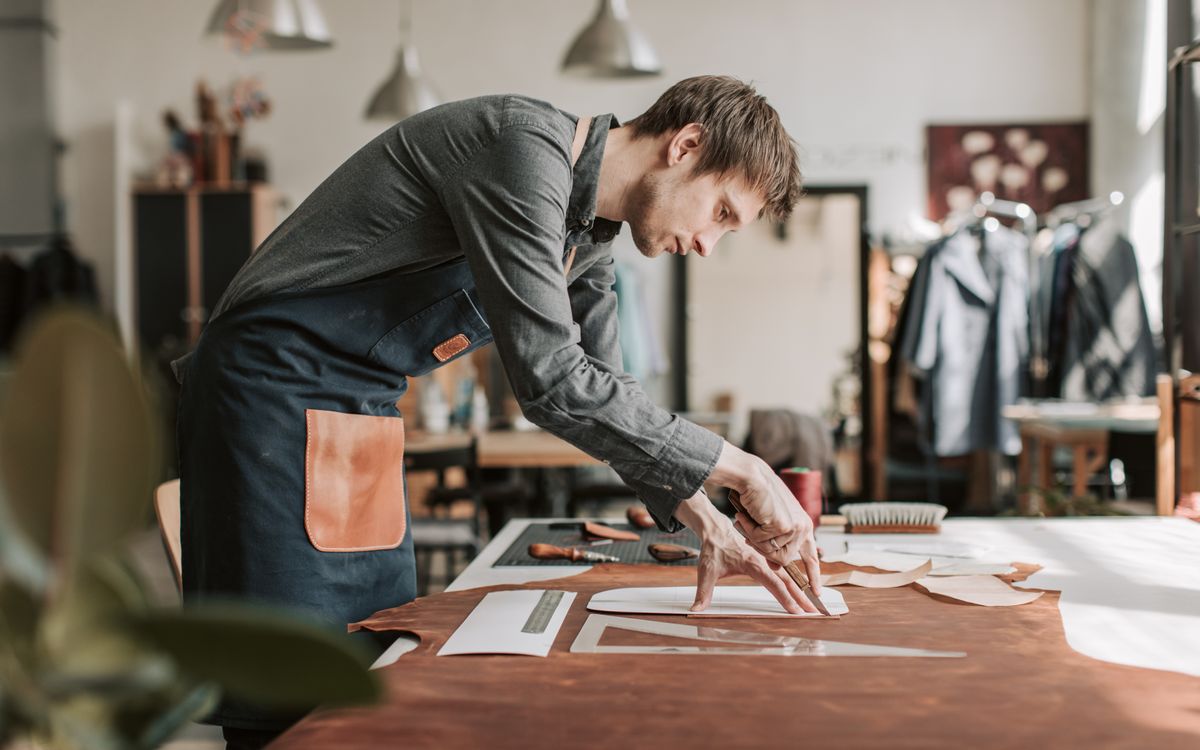 A skilled craftsman working leather by hand in a traditional workshop
