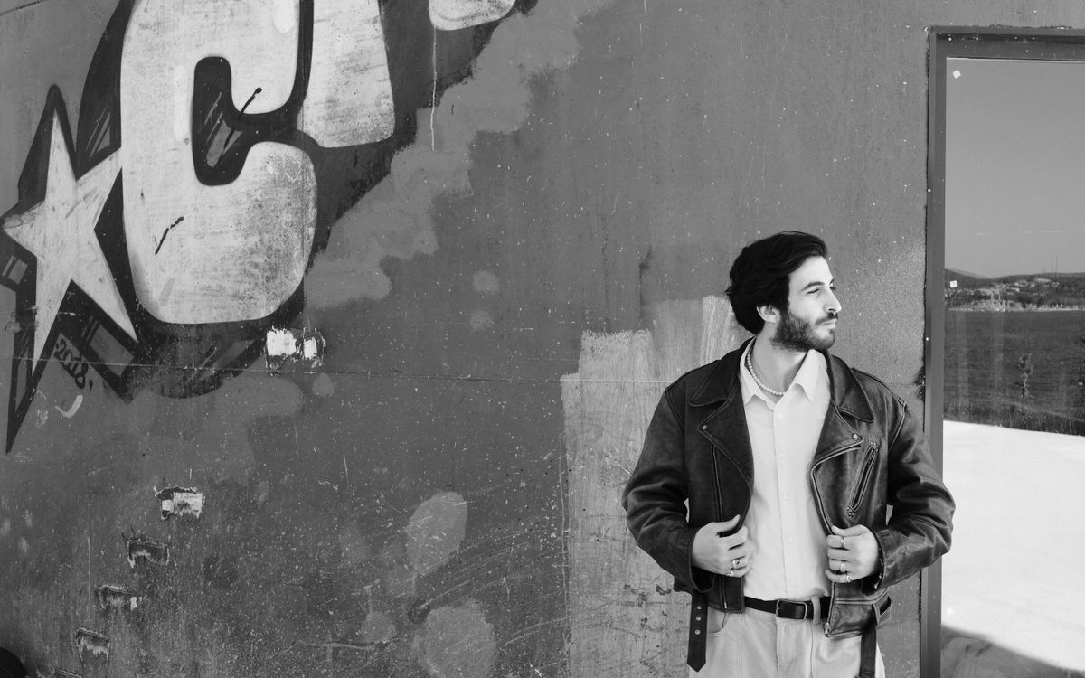 A figure in a leather jacket against an urban backdrop, rugged and protective