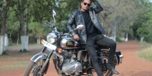 A stylish figure in a black leather jacket against a moody backdrop