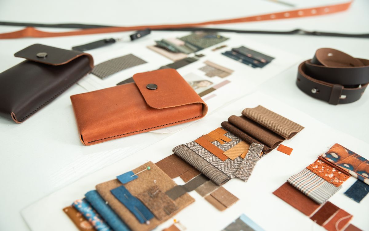 Colourful, finely worked leather goods on an artisan's table