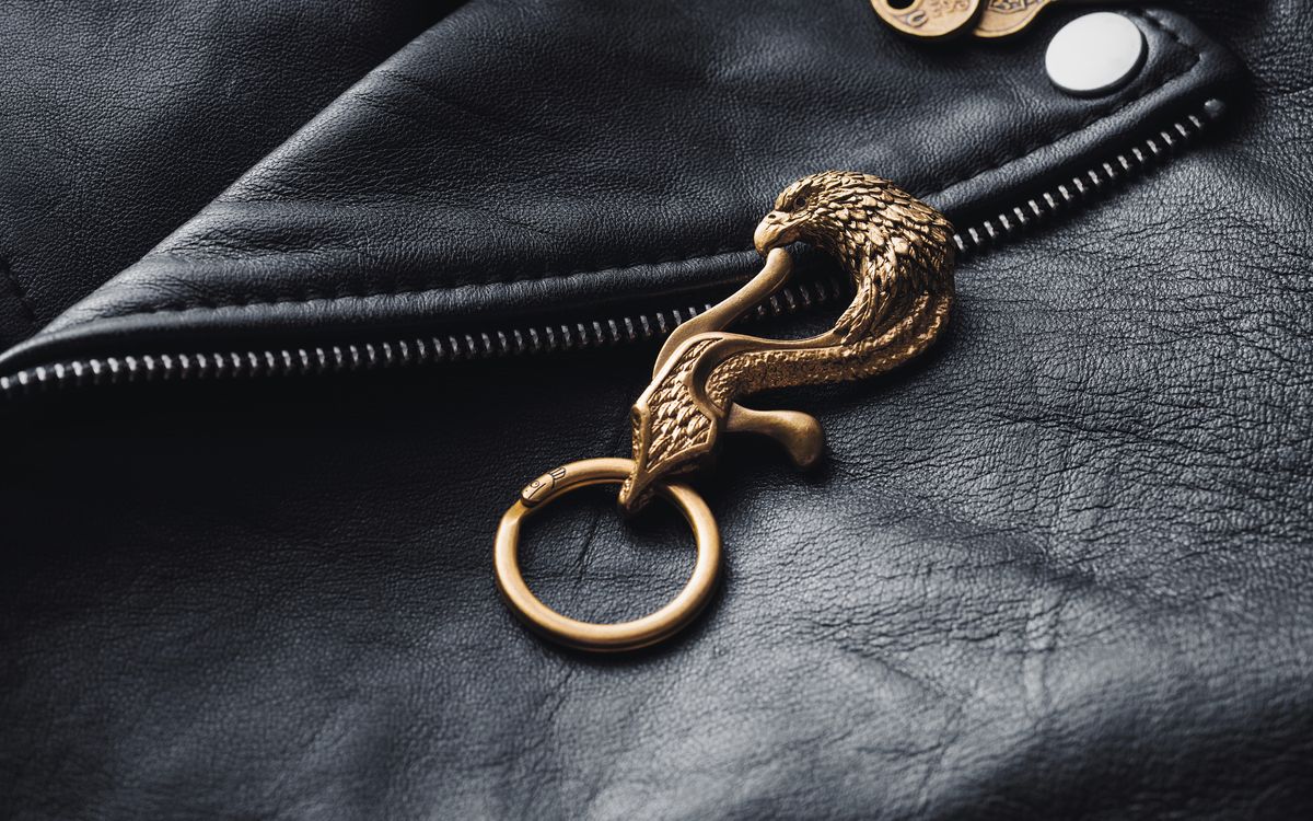 Close-up of a detailed brass hardware detail on a textured leather jacket