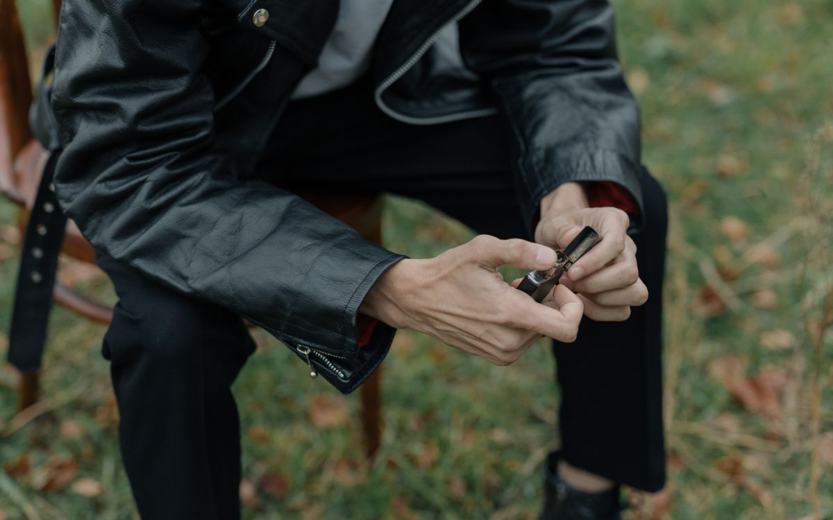 Person in a leather jacket sitting outdoors