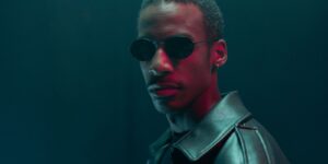 Stylish portrait of a man in sunglasses and a leather jacket with a dramatic, moody ambiance
