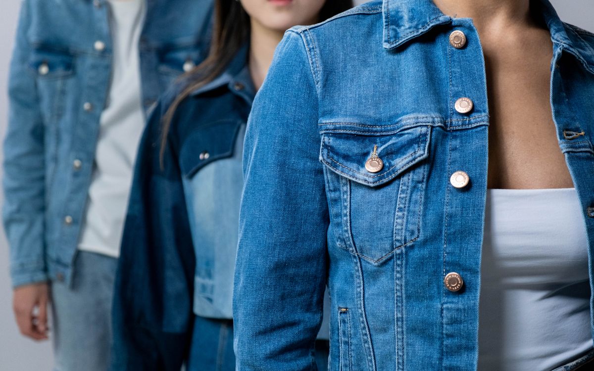 Group of people modeling stylish denim jackets in studio setting