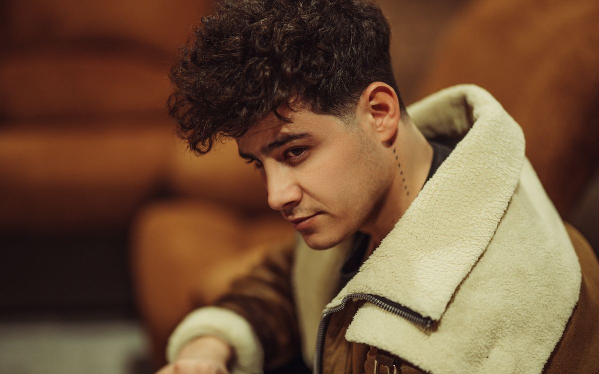 Model posing indoors in a fashionable shearling jacket