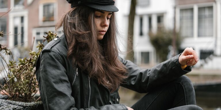 Close-up of a peeling leather jacket sleeve showing cracked surface finish
