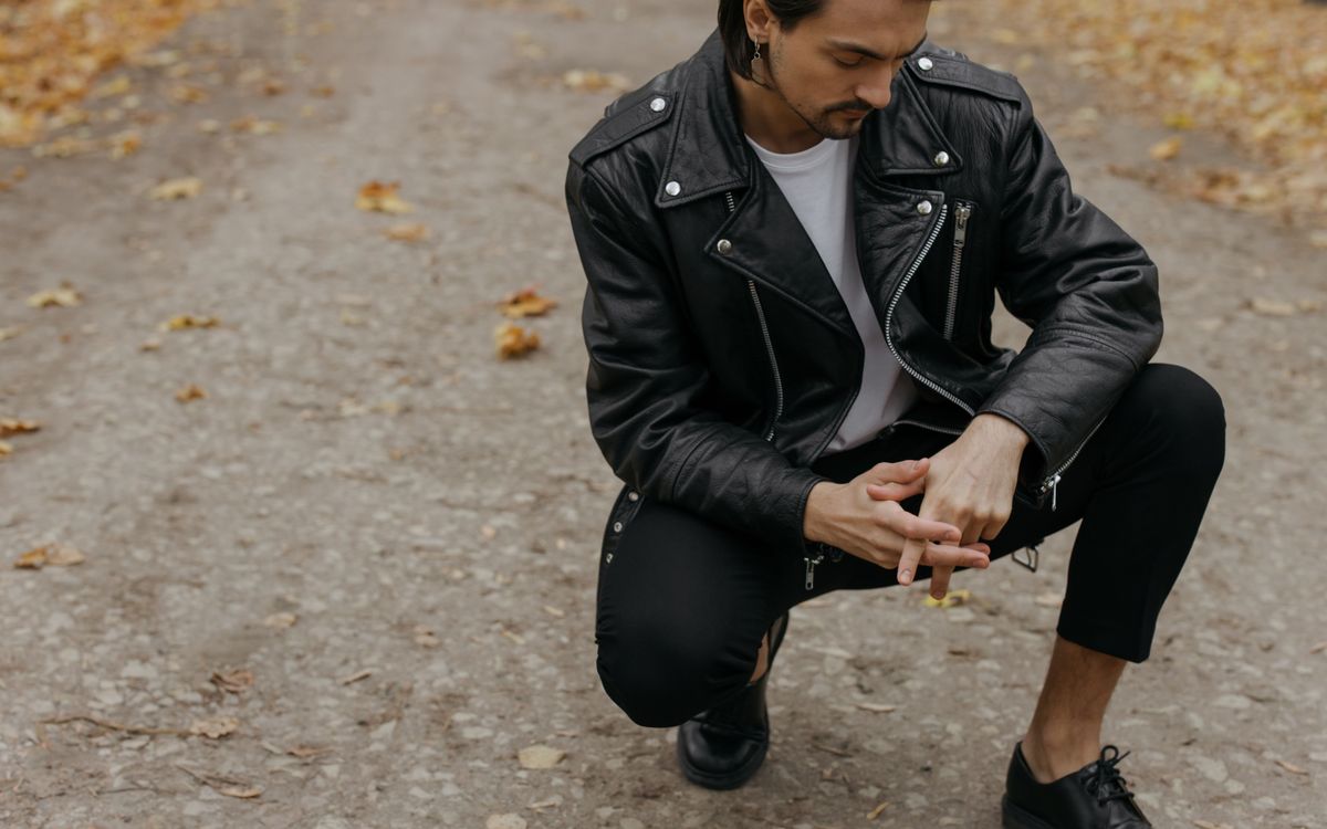 Man in a leather jacket relaxing outdoors during autumn