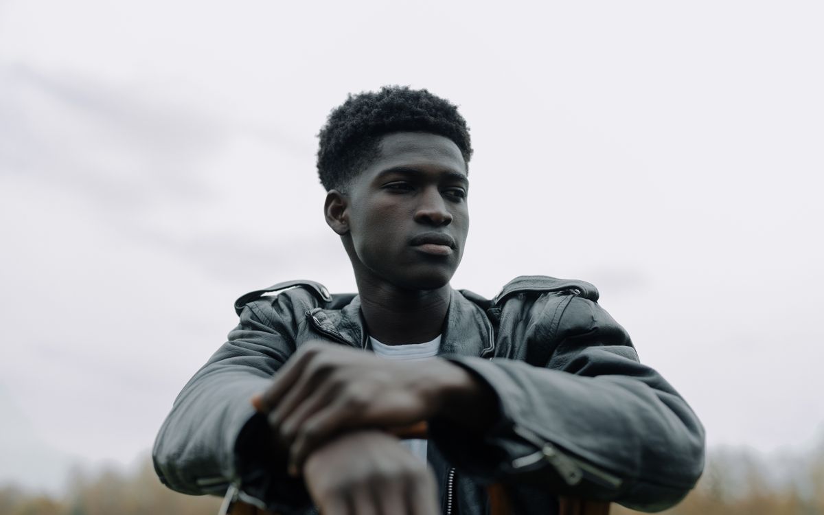 Outdoor portrait of a thoughtful young man in a black leather jacket, exuding confidence and style