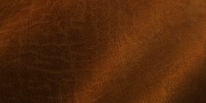 Close-up of rich brown leather texture with subtle grain patterns and a soft finish