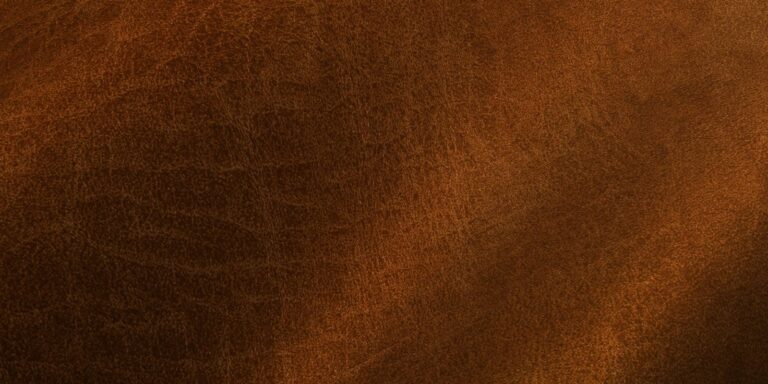 Close-up of rich brown leather texture with subtle grain patterns and a soft finish