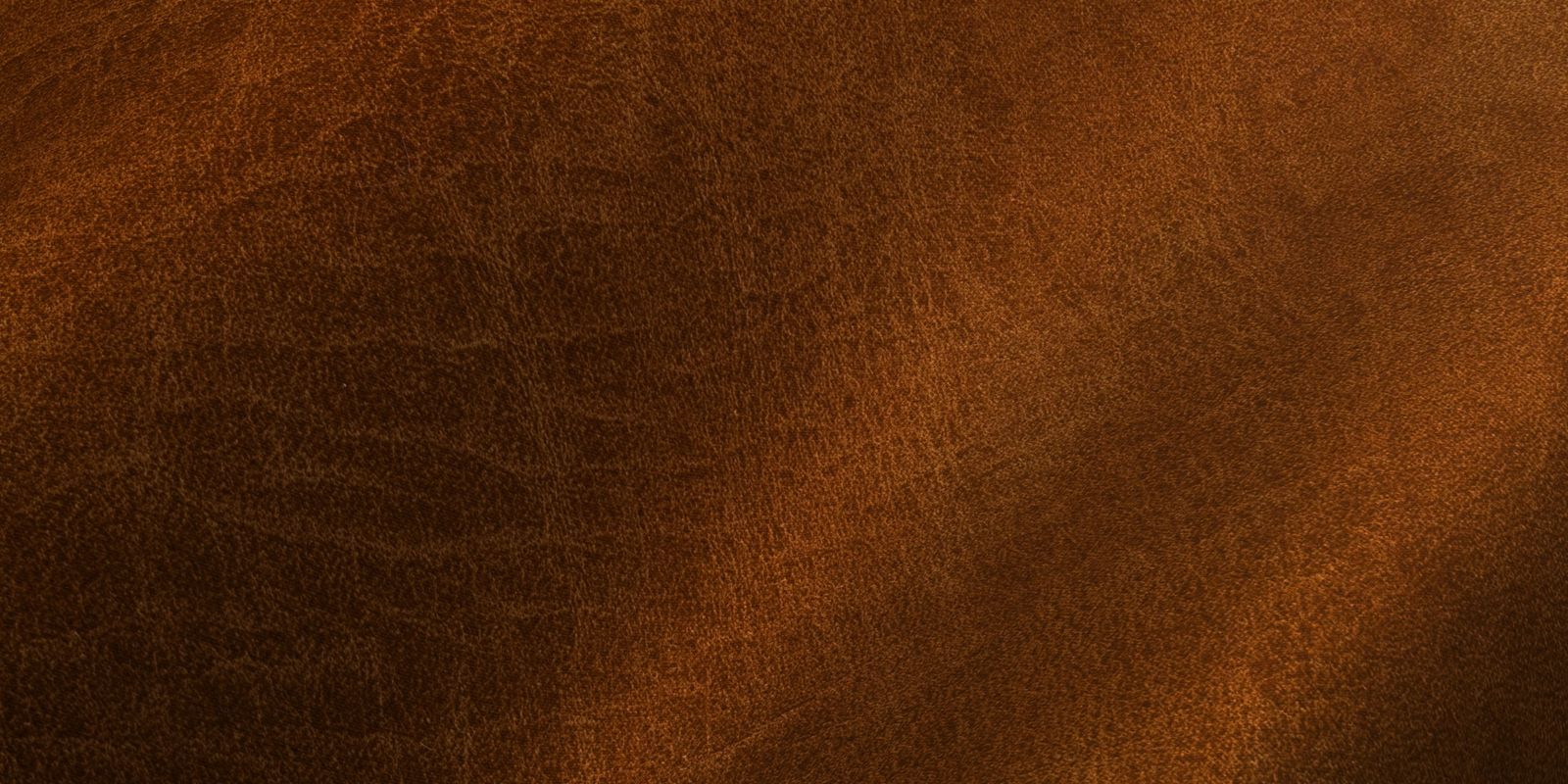 Close-up of rich brown leather texture with subtle grain patterns and a soft finish