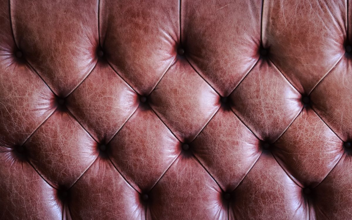 Close-up of tufted brown leather upholstery showcasing a vintage texture