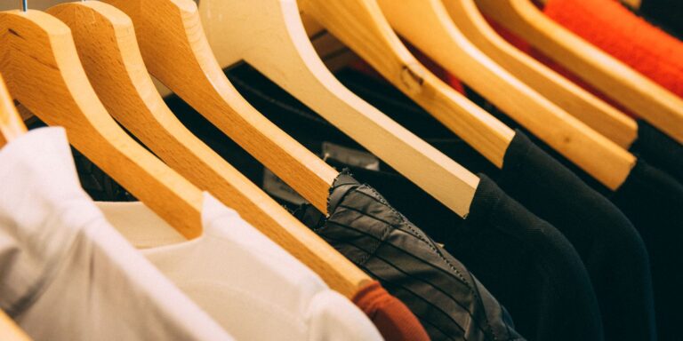 Row of jackets hanging neatly on wooden hangers in a wardrobe