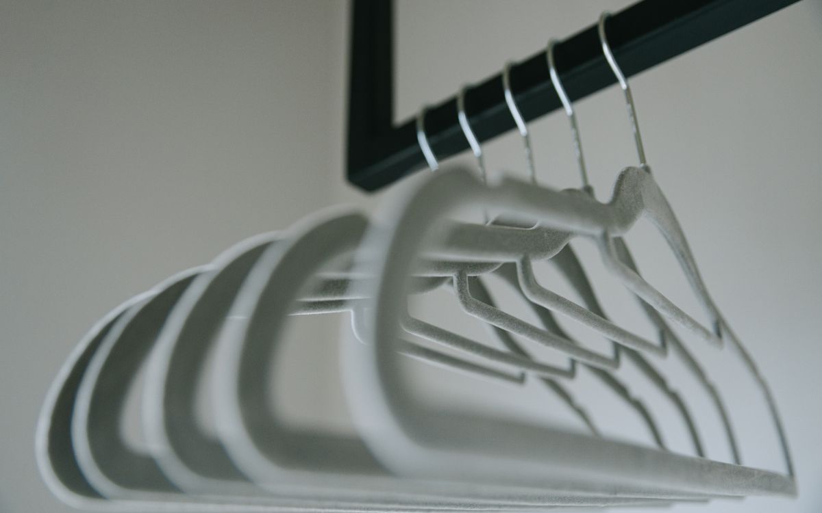 Minimalist felt coat hangers arranged neatly on a clothes rack