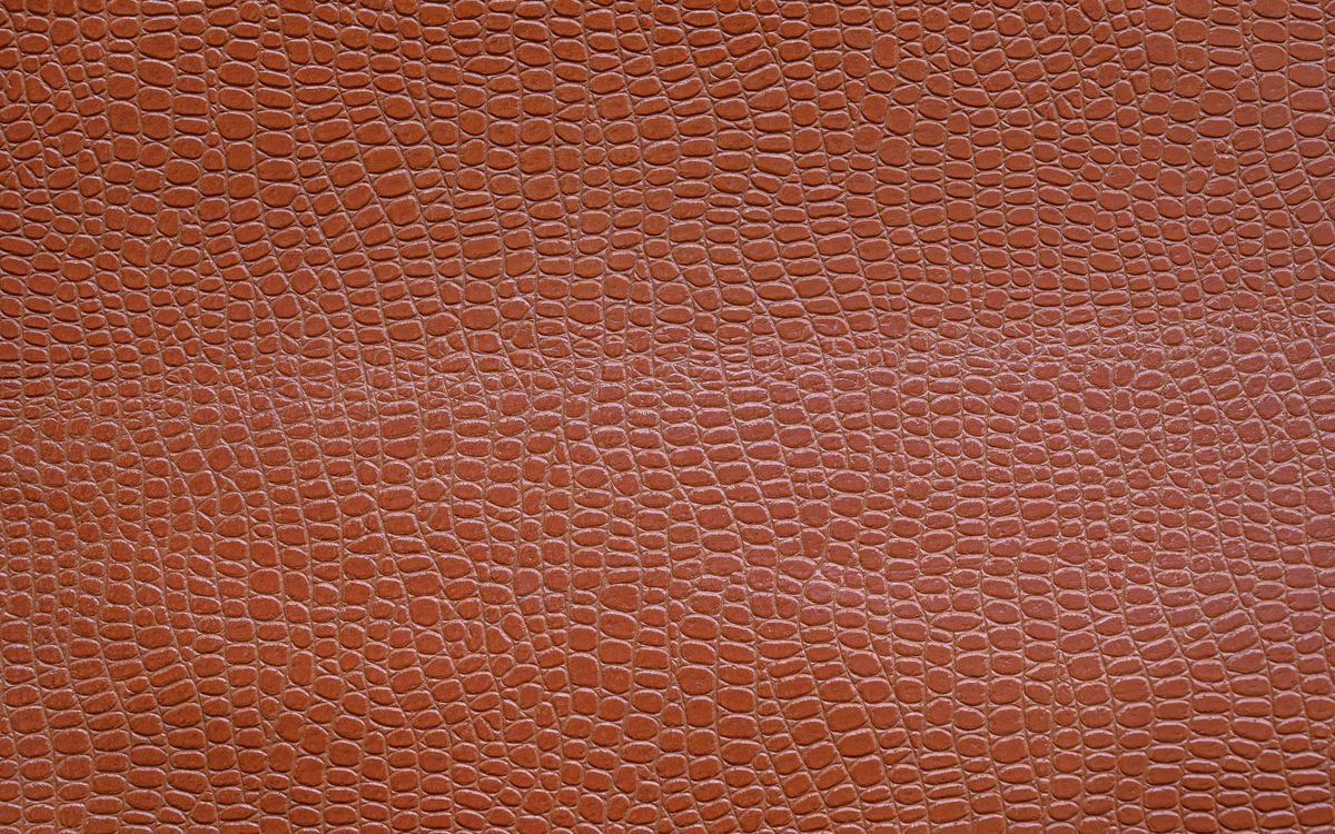 Close-up of a textured brown leather surface showing the natural grain pattern