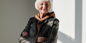 A senior woman exudes confidence and style in a black leather jacket with a warm smile
