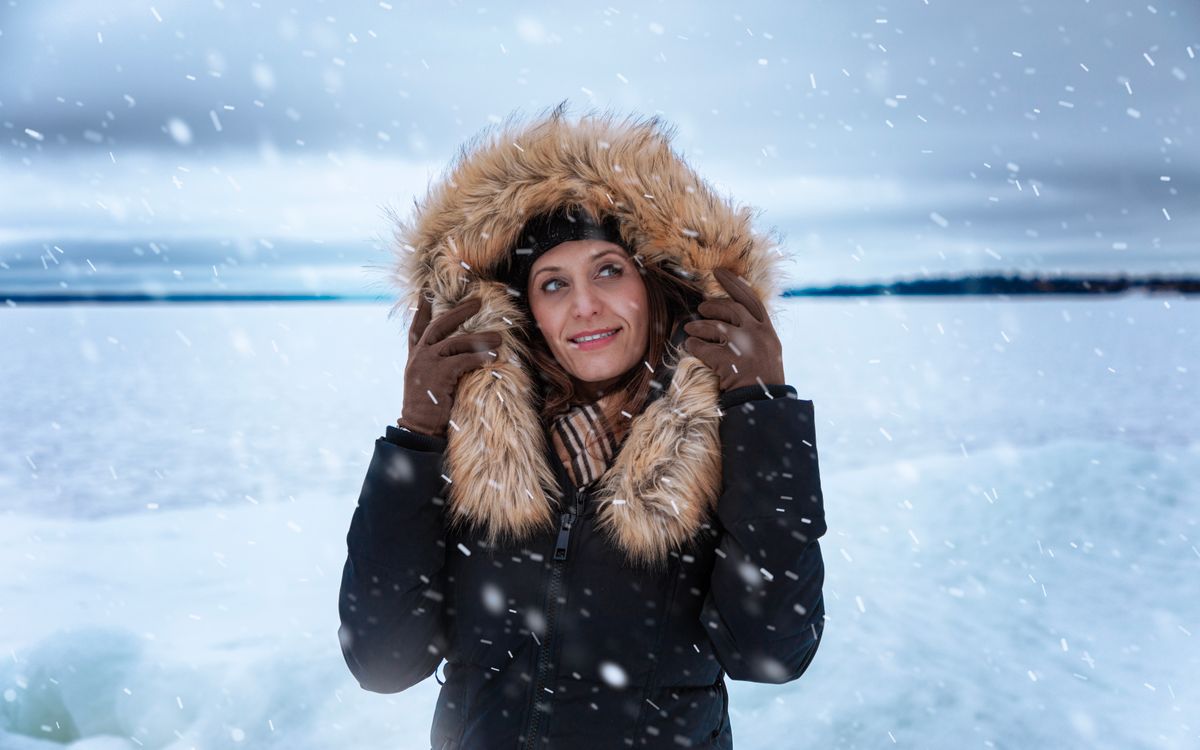 A woman in a fur-trimmed coat outdoors on a snowy day