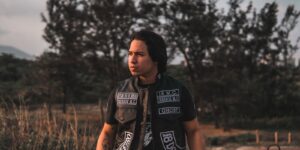 Man wearing a black leather vest outdoors in natural daylight