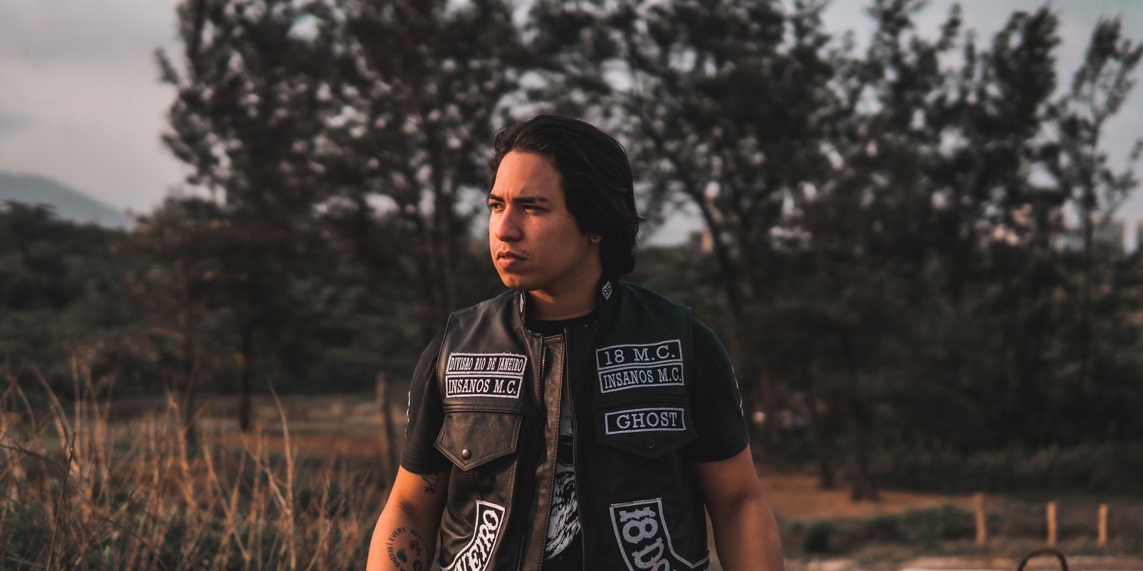 Man wearing a black leather vest outdoors in natural daylight