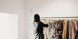 A woman browsing leather jackets on a rack in a bright, stylish boutique