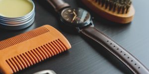 Close-up of a leather care brush and cleaning products laid out next to leather