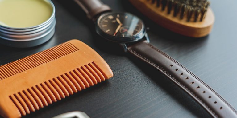 Close-up of a leather care brush and cleaning products laid out next to leather