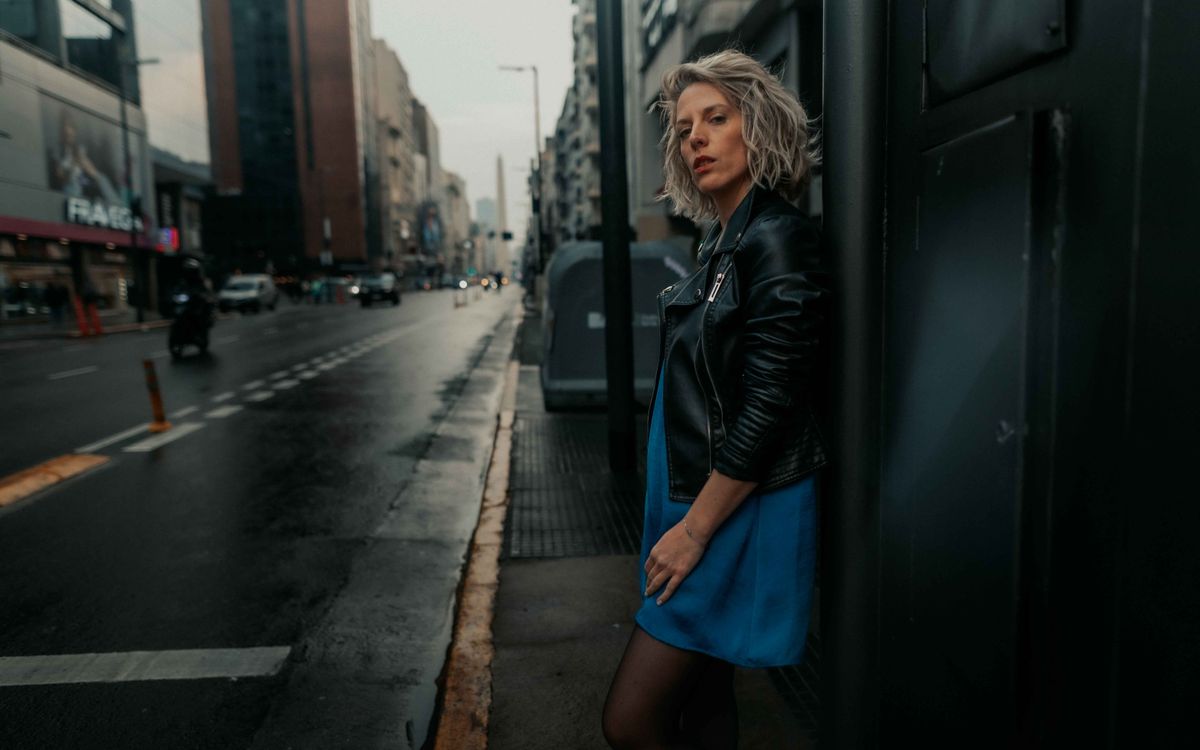 Fashionable woman in a leather jacket on a city street in the rain