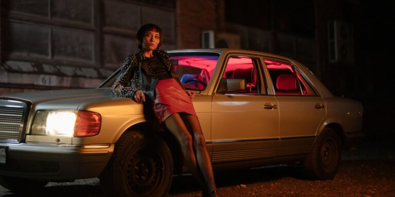 A fashionable woman in a leather jacket styled with a skirt in a city setting