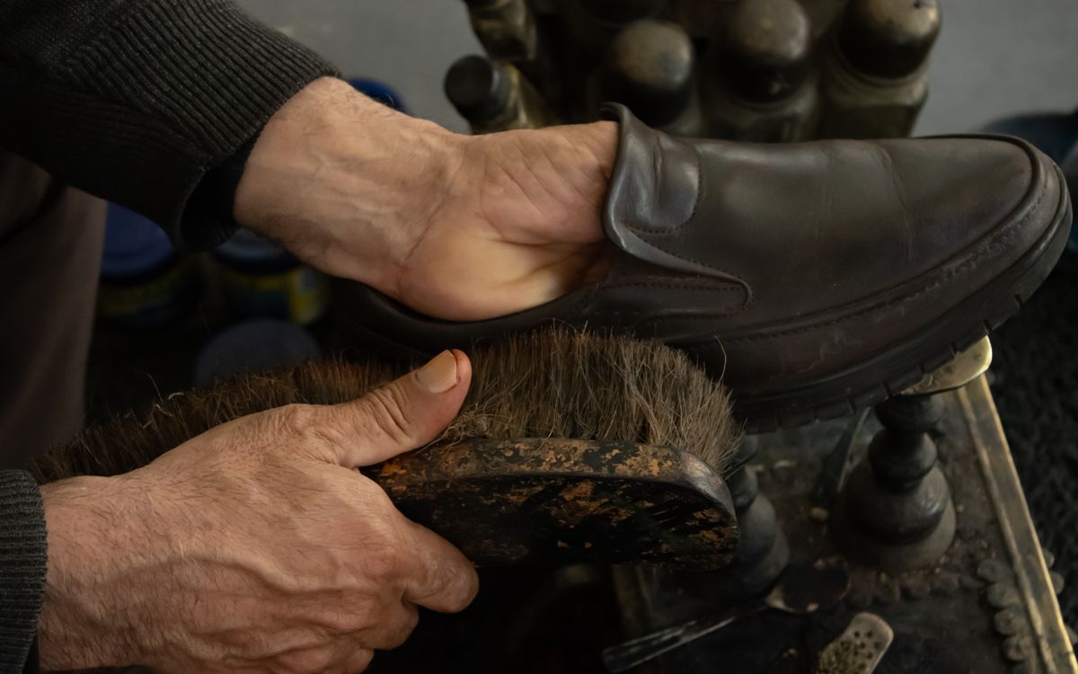 Careful hand-brushing and polishing of leather in a workshop, part of a full restoration