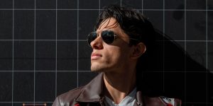 Portrait of a man in sunglasses and a leather jacket against a dark background