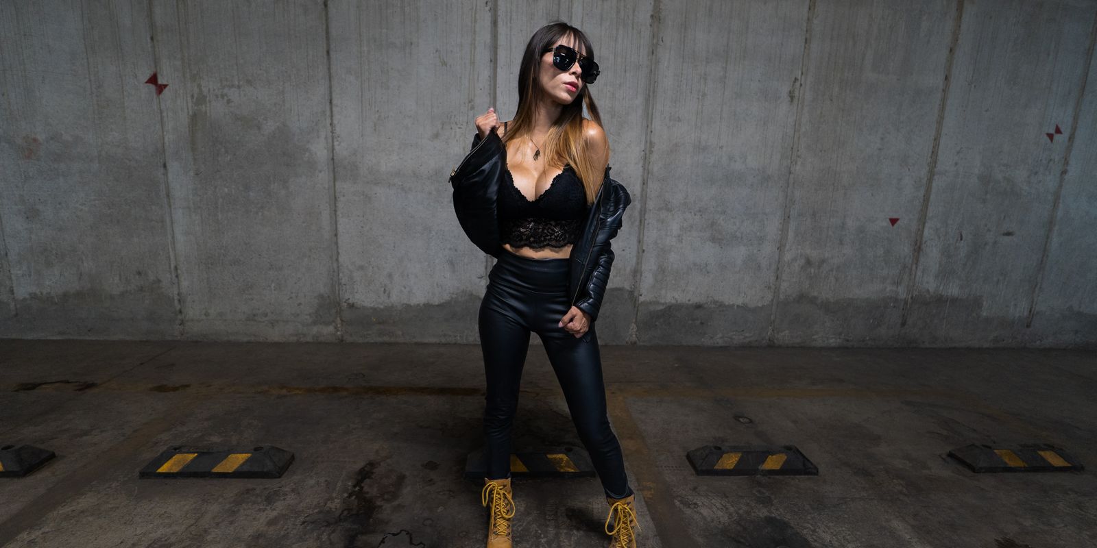 A stylish woman in a black leather jacket posing confidently in an urban street
