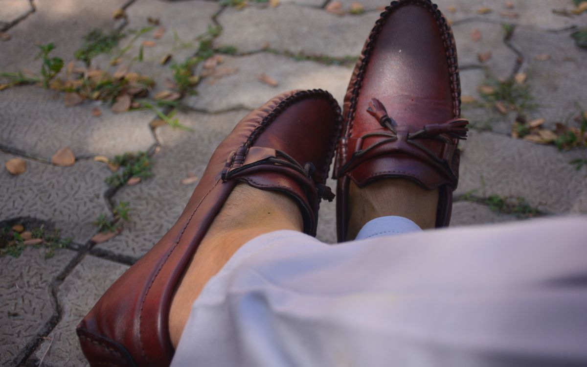 Maroon leather loafers on a sunny street