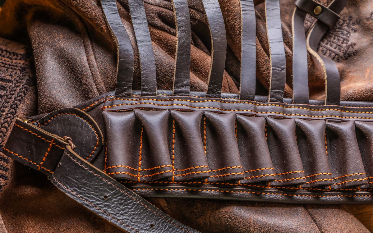 Close-up of a brown leather jacket showing texture and a leather belt detail