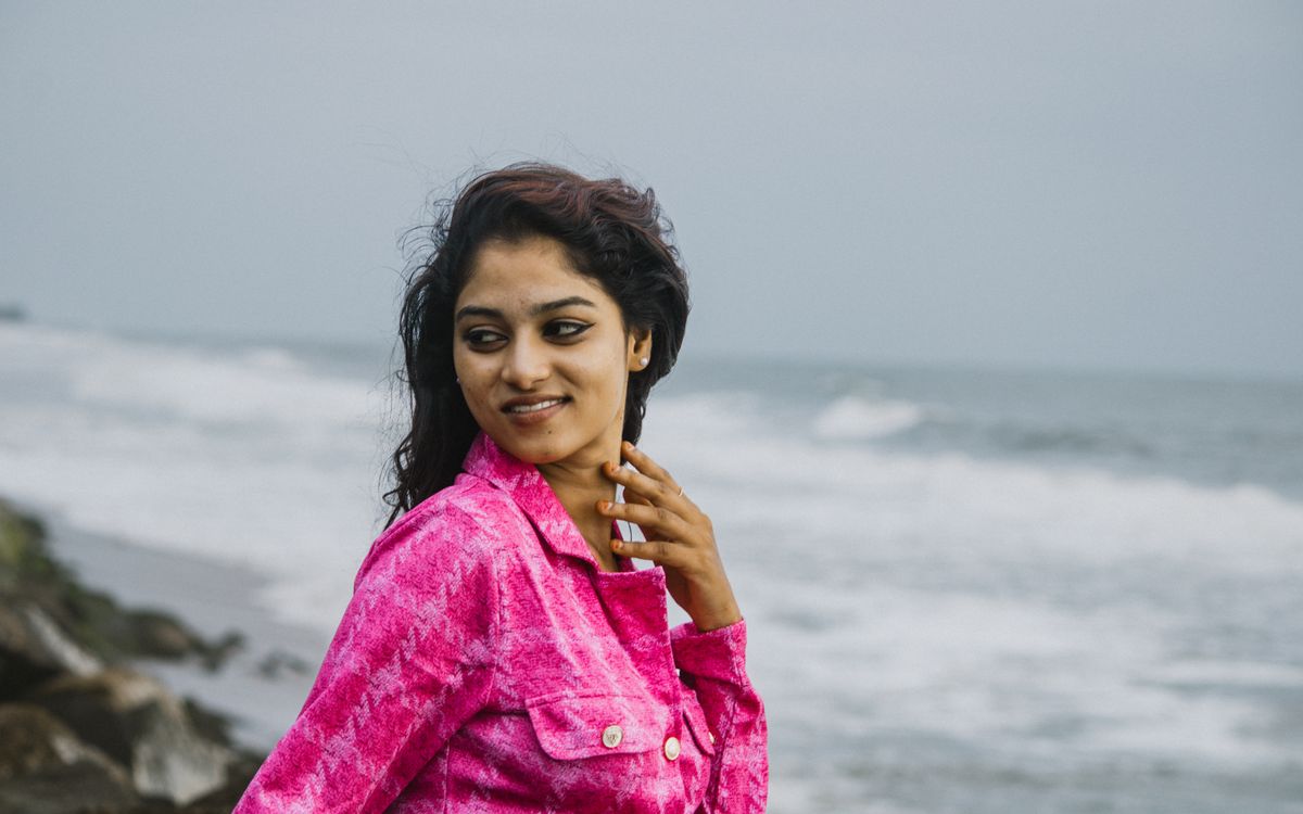 Smiling woman wearing a vibrant pink leather jacket outdoors